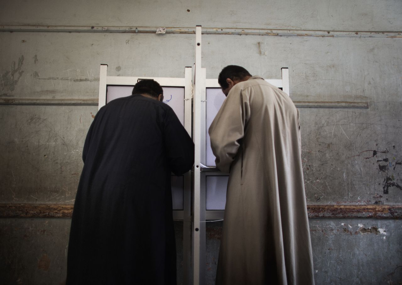 Egyptian men fill out their ballots Wednesday in Cairo. Results of the first round of voting are not expected before the weekend.