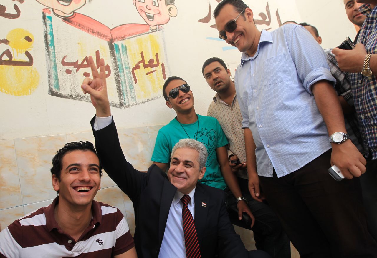 Presidential candidate Hamdeen Sabahy, a leftist dark-horse contender, flashes a sign of victory as he waits to vote at a Cairo school.