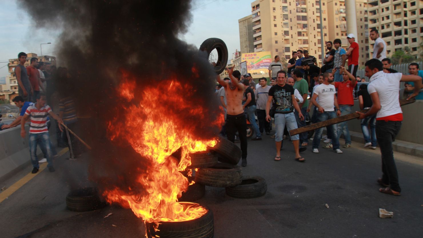Shiite Muslim youths set tires on fire to block a road at the entrance of Beirut's southern suburbs on Tuesday. 
