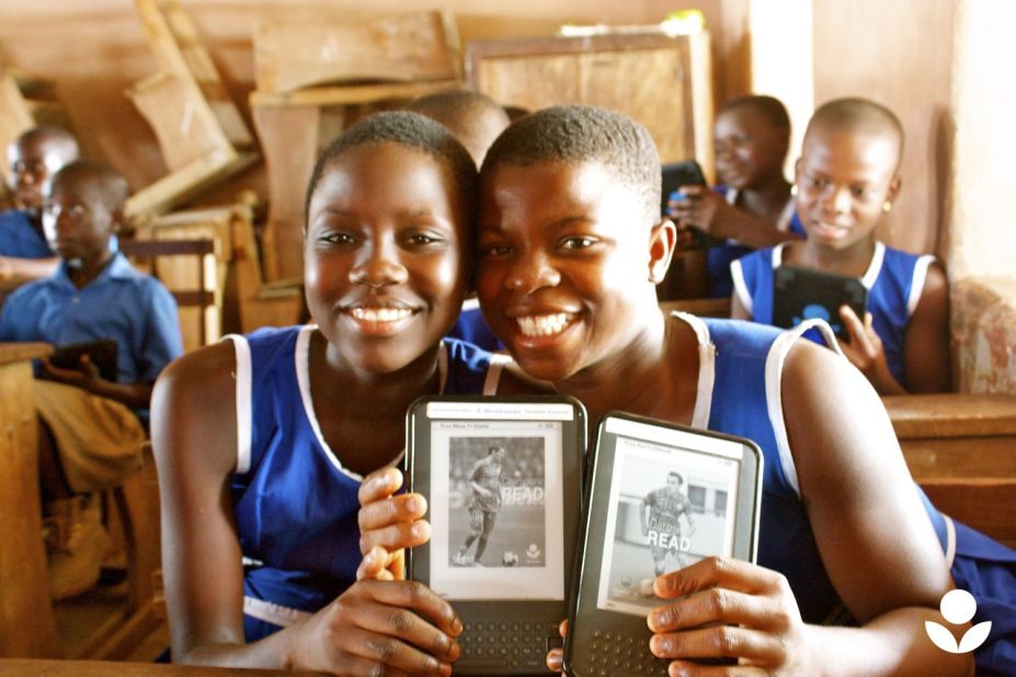 Two participants in the pilot project in Ghana hold up messages of encouragement from FC Barcelona stars Lionel Messi and Xavi. Students on the pilot gained access to an average of 107 titles through their devices, as opposed to the three to 11 books the average student had access to at home.