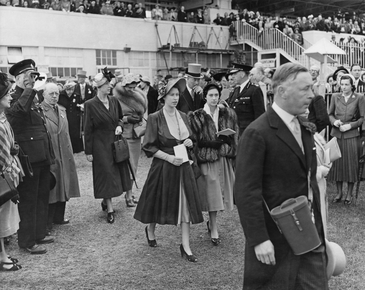 A fan of horse racing from a young age, then-Princess Elizabeth is seen walking through the paddock at the Epsom Downs racecourse during the derby on May 27, 1950. An appearance at Epsom Derby would be her first official engagement as queen several years later.