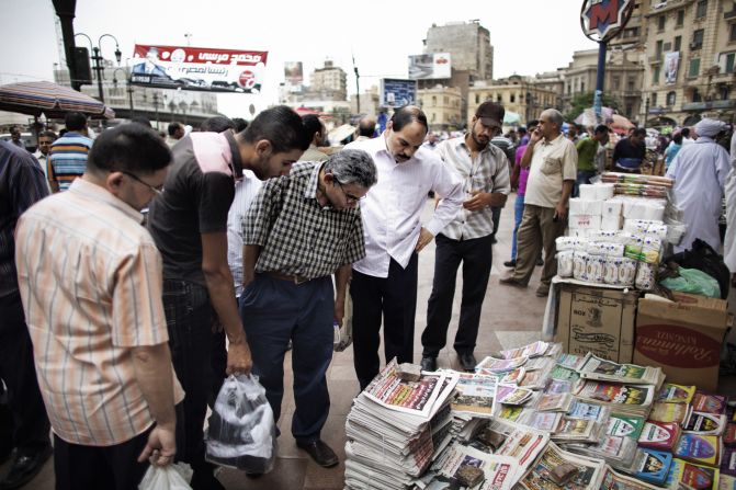 Egyptians read the front page of newspapers for sale outside of Al-Fatah Mosque in Cairo on Friday, May 25.