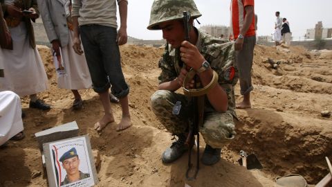A Yemeni soldier sits next to the grave of a comrade who was killed in a suicide bombing earlier in the week.