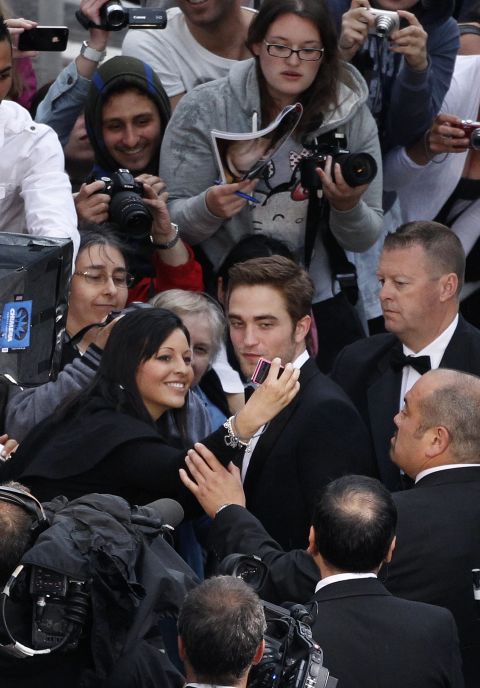 British actor Robert Pattinson signs autographs and poses for photos with fans prior to the screening of "Cosmopolis" on Saturday.