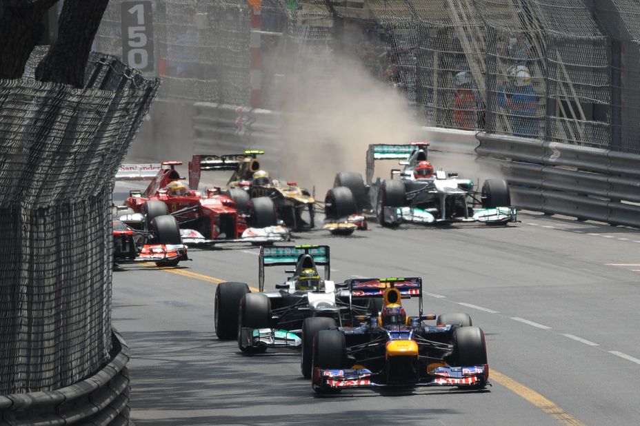 Red Bull driver Webber leads the way but behind him Romain Grosjean forces Michael Schumacher to go wide in an early clash.