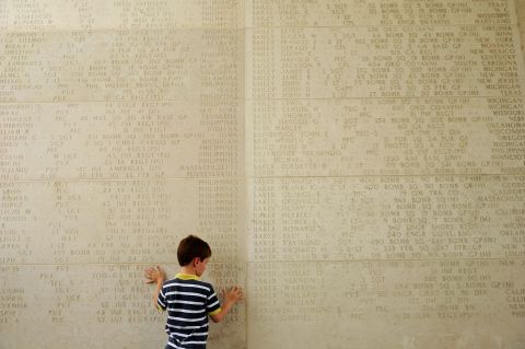 A boy traces the names of soldiers who died during World War II at a service Sunday to mark Memorial Day at the Manila American Cemetery in the Philippines.