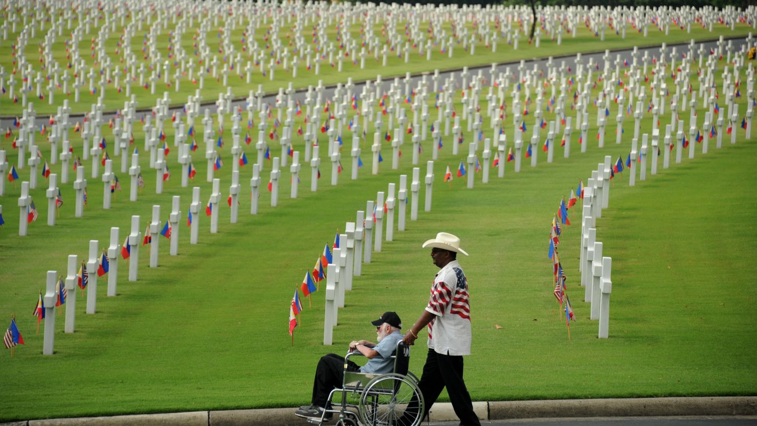A man pushes an elderly man in a wheelchair among the graves of soldiers who fell during World War II at the Manila American Cemetery in Fort Bonifacio in the Philippine capital on May 27, 2012. 