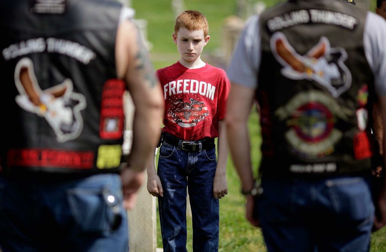 Martin Given, 12, of Springfield, New Jersey, stands with U.S. veterans including his father, Mark Given, who served in the Army for eight years, during a wreath-laying ceremony Friday at the Congressional Cemetery in Washington.
