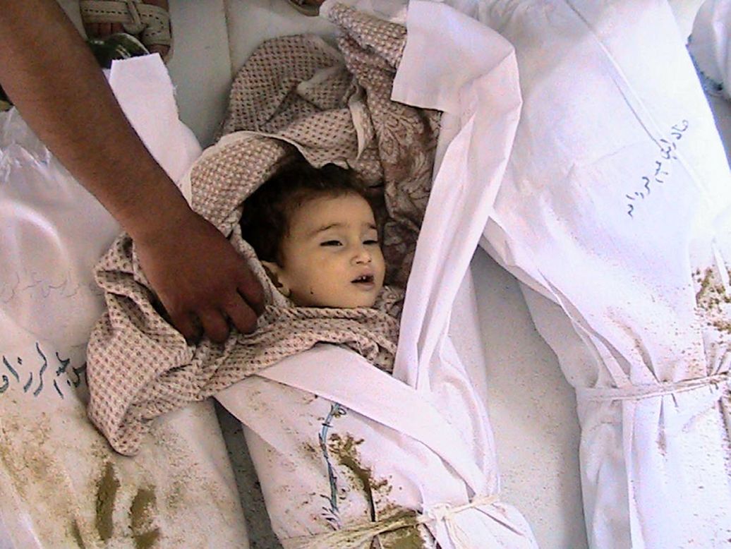 The body of a slain Syrian child lies next to other shrouded bodies at a hospital mortuary in Houla on Saturday in another photo from the opposition Shaam News Network. Al-Assad's regime insists it is not behind the massacre and blames terrorist groups. Syria has attributed violence on "armed terrorist groups" throughout the 14-month-old uprising.