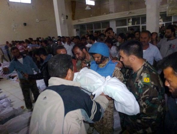 A Houla resident shows a body to a U.N. observer at a mosque in the central Syrian town. Some U.N. Security Council members condemned the attacks "that involved a series of government artillery and tank shellings on a residential neighborhood" as well as killings of civilians by close-range gunshots.