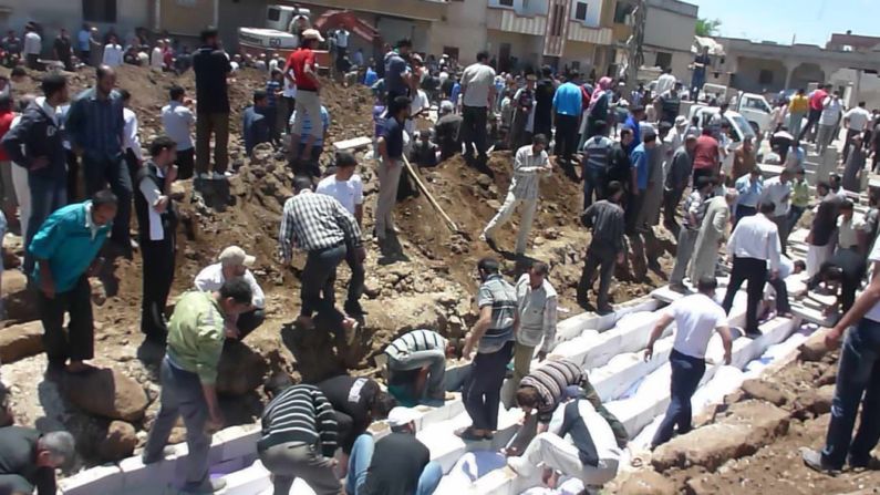 Syrians gather at a mass burial Saturday in Houla. "Those responsible for these brutal crimes must be held accountable," Kofi Annan, the U.N.-Arab League special envoy, said in a statement.