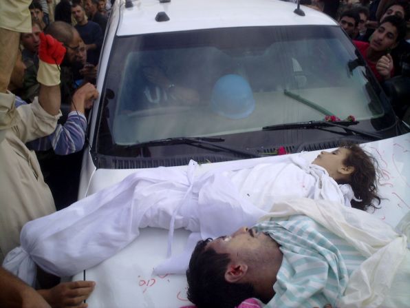 Syrians surround a U.N observer vehicle after placing the bodies of a girl and man on the car in Houla on Saturday, May 26, 2012. The photo is from the opposition Shaam News Network. Forty-nine children were among the 108 slaughtered in Houla on Friday, May 25, U.N. monitors say. The massacre in Houla, a suburb of the anti-government bastion of Homs, has reignited international fury against Bashar al-Assad's regime.