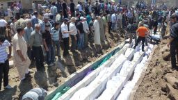 A handout picture released by the Syrian opposition's Shaam News Network shows people at a mass burial on Monday.