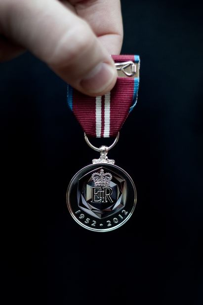 A British soldier holds a medal specially created for the diamond jubilee celebrations. Soldiers from the Household Cavalry Mounted Regiment will escort the queen during her procession on June 5. 