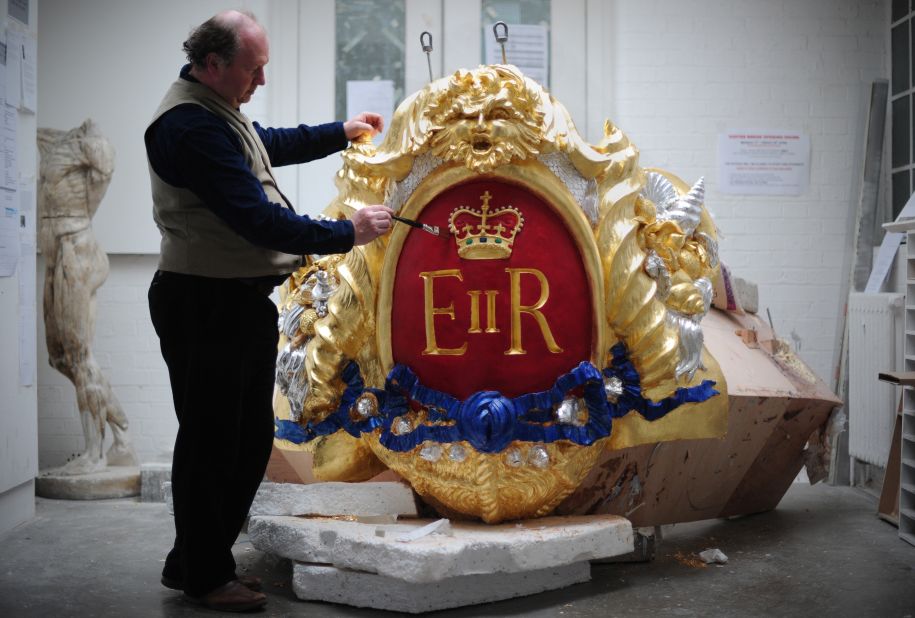 Head of Historic Carving Alan Lamb, poses next to the royal cypher that will decorate the Royal Barge in which the queen will travel along the Thames during the river pageant on June 3. 