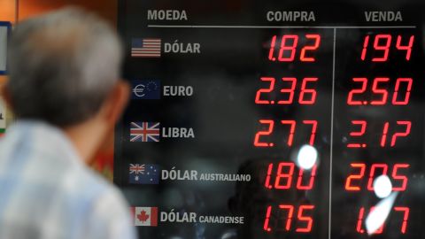 A man watches the foreign currencies exchange rate  in Rio de Janeiro, Brazil.