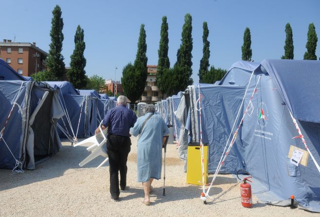 Elderly people walk in a temprorary emergency camp after the earthquake in Mirandola; the government declared a state of emergency in the quake area.