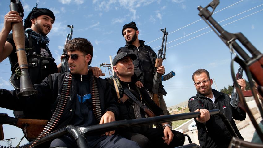 Syrian fighters from a group calling themselves 'The right bombs squad', many of who left their studies and jobs to join rebels, hold their weapons at a checkpoint controlled by the Free Syrian Army (FSA) at Epin, in the north-western province of Idlib, on April 15, 2012. 
