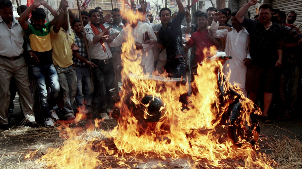 	Shiv Sena activists chant slogans after setting fire to a scooter during a strike against a petrol price hike in Jammu on May 31, 2012