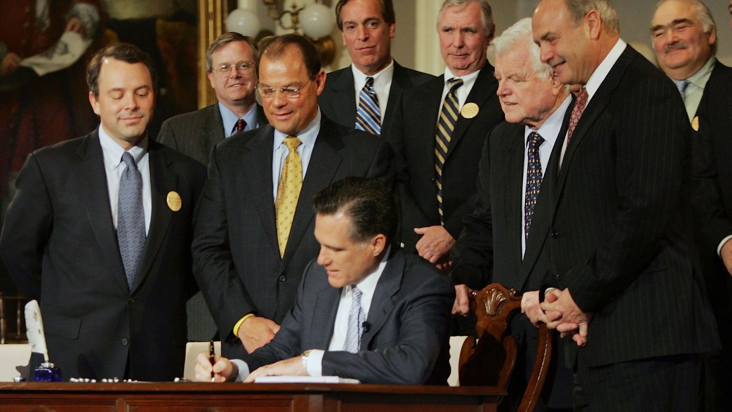 Gov. Mitt Romney signs into law a health care reform bill during a ceremony at Faneuil Hall on April 12, 2006, in Boston.