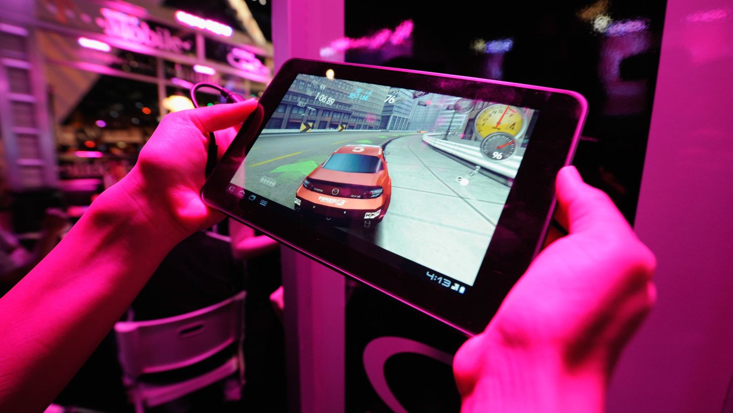An exhibitor plays a racing game on a tablet at last year's E3. Gaming has been expanding from consoles to mobile devices.