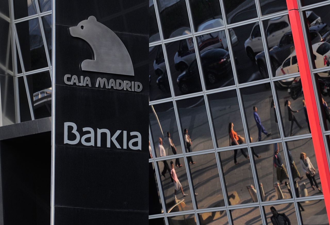 Commuters are reflected on the headquarters of Bankia SA on May 29, 2012 in Madrid, Spain. Spanish borrowing costs have increased after the government announced a rescue plan for Bankia involving more public debt. 