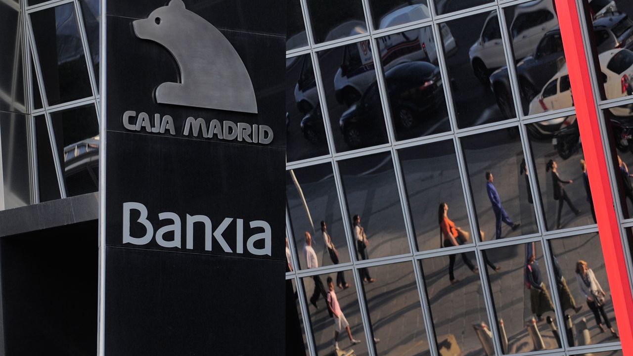 Commuters are reflected on the headquarters of Bankia SA on May 29, 2012 in Madrid, Spain. 