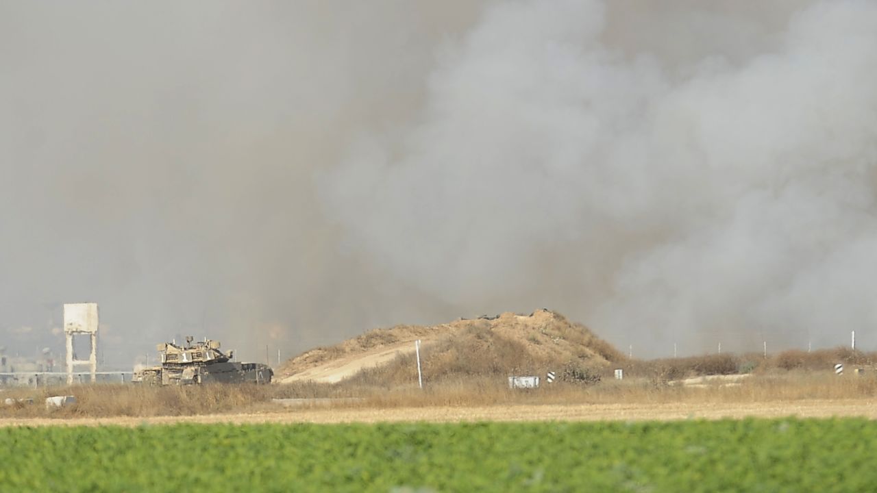 Smoke billows from the Gaza Strip as an Israeli army tank monitors the area on the southern Israel-Gaza border Friday.