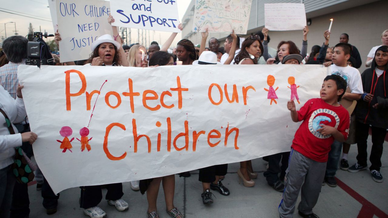 Parents and children march near Miramonte Elementary, protesting teacher misconduct in California schools.