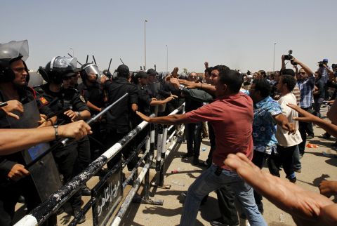 Protesters and police officers clash after the announcement of Mubarak's guilty verdict.