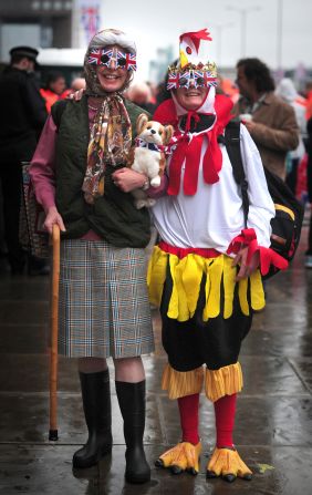 Two pageant spectators dressed as the queen (complete with corgi) and a "coronation chicken" pose for a photograph along the River Thames. Thousands are expected to turn out for the pageant to celebrate the queen's Diamond Jubilee