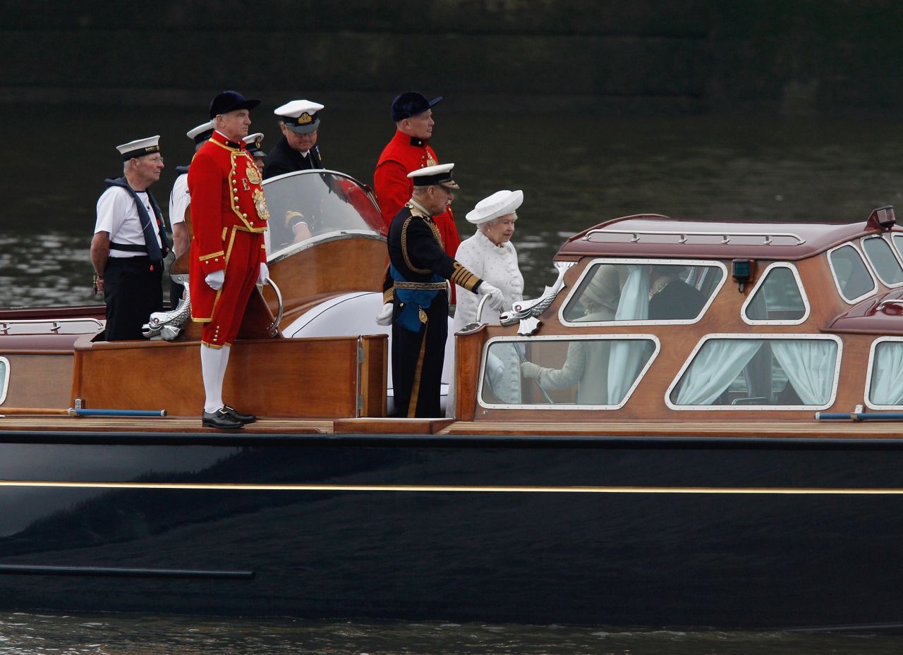 The queen and the Duke of Edinburgh leave the docks and head out on to the water to the beginning of the Thames River Pageant.