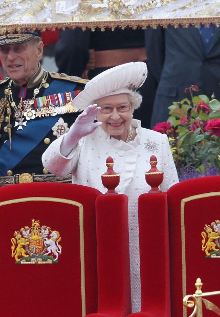 Britain's Queen Elizabeth II waves to thousands along the Thames as the royal barge makes its way down the river.