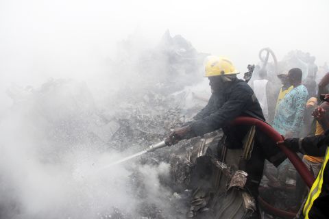 Firefighters work at the scene of the crash. The Dana Air flight from Abuja plunged into a building several miles from the airport in Lagos.