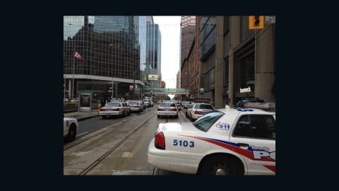 Police, firefighters and paramedics gather at Toronto's Eaton Centre shopping mall after reports of a shooting.
