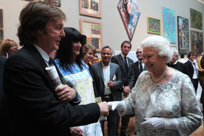 Britain's Queen Elizabeth II meets Paul McCartney and his wife Nancy Shevell as she visits the Royal Academy of Arts in central London
