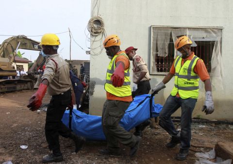 Rescue workers remove a victim of Sunday's plane crash in a Lagos, Nigeria, residential area on Monday, June 4. All 153 people aboard were killed.