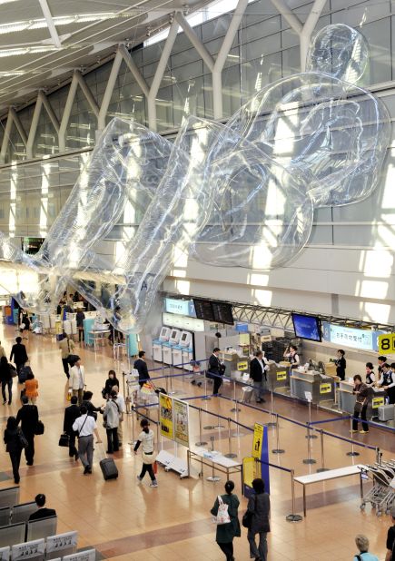 A human-shaped plastic balloon floats in the air above the concourse of Tokyo's Haneda Airport as part of a temporary public art installation in March 2009.