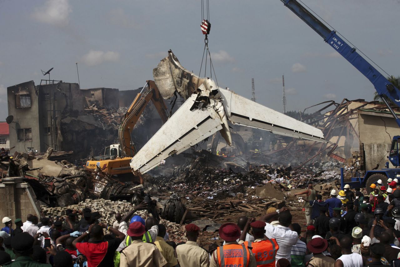 The scene is surrounded by onlookers as pieces of the wreckage and debris are cleared Monday.