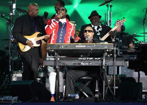 Singers Will.i.am and Stevie Wonder perform on stage. Wonder altered the lyrics to some of his songs to pay tribute to the queen.