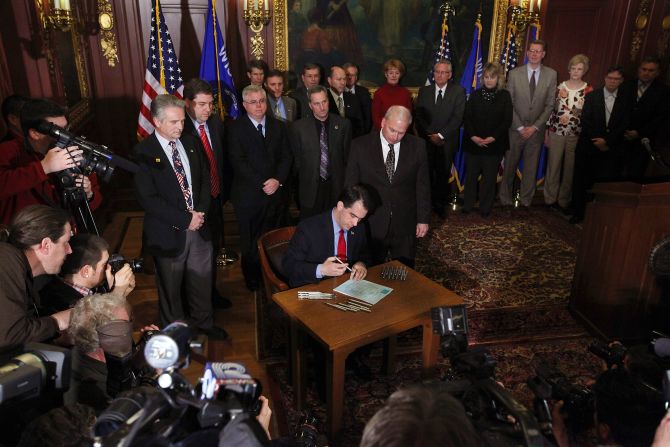 On March 11, 2011, Walker signs a bill that ends the collective bargaining rights of public employees as a measure to close the state's budget shortfall.
