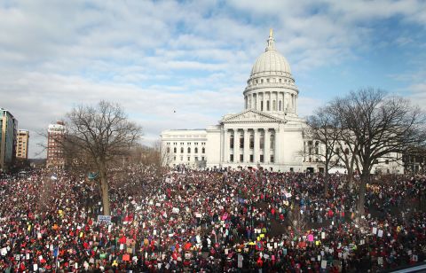 Thousands of demonstrators gather outside the Wisconsin State Capitol in Madison the following day to protest the bill signing.