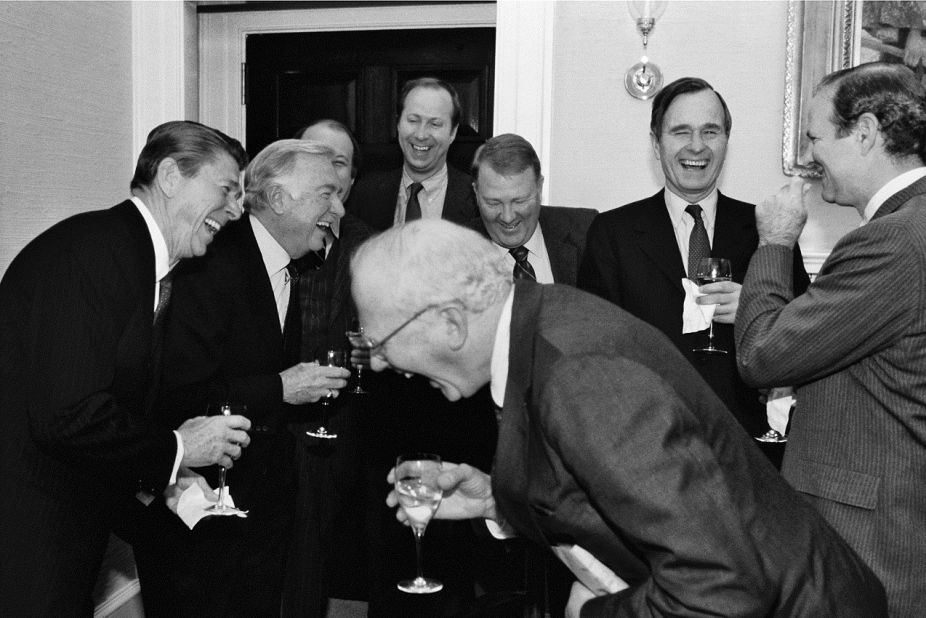 President Reagan, left, Cronkite, presidential staffers Jim Brady and David Gergen, then-Attorney General Ed Meese, then-Vice President George Bush, chief of staff James Baker, and CBS News' Bud Benjamin laugh at a 1981 White House party. 