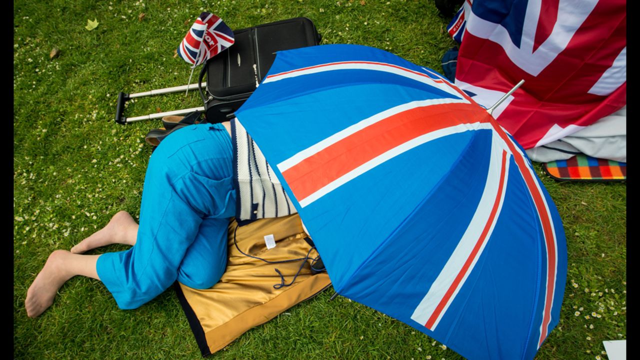 A woman takes refuge under a Union Jack umbrella in St Jame's Park.  