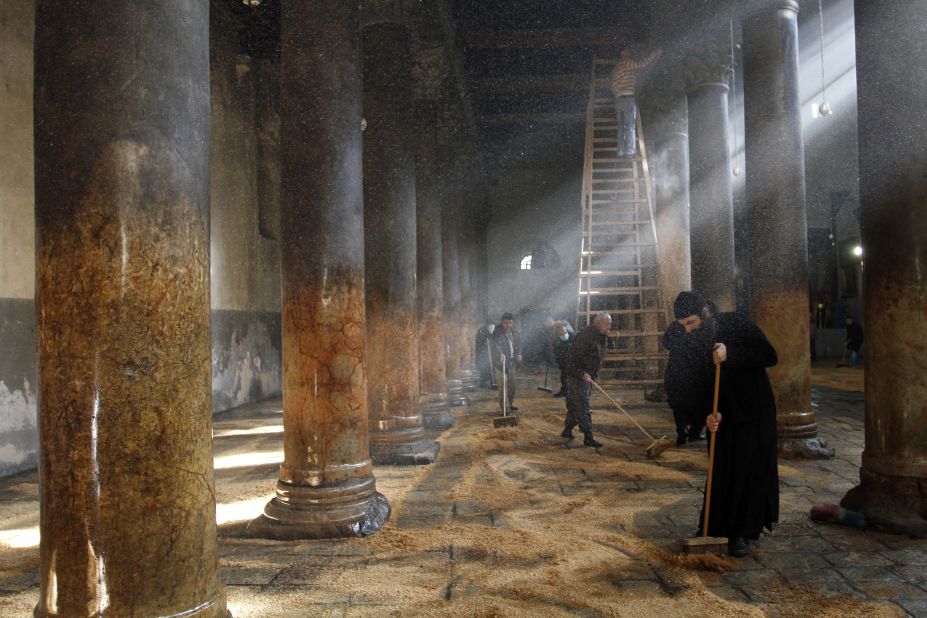 Orthodox clergy cleaning the Church of Nativity. Responsibilities for cleaning the church are split between the three denominations that administer the church, who have been known to erupt in scuffles.