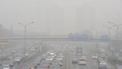 Vehicles make their way along a road on a smoggy day in Beijing.
