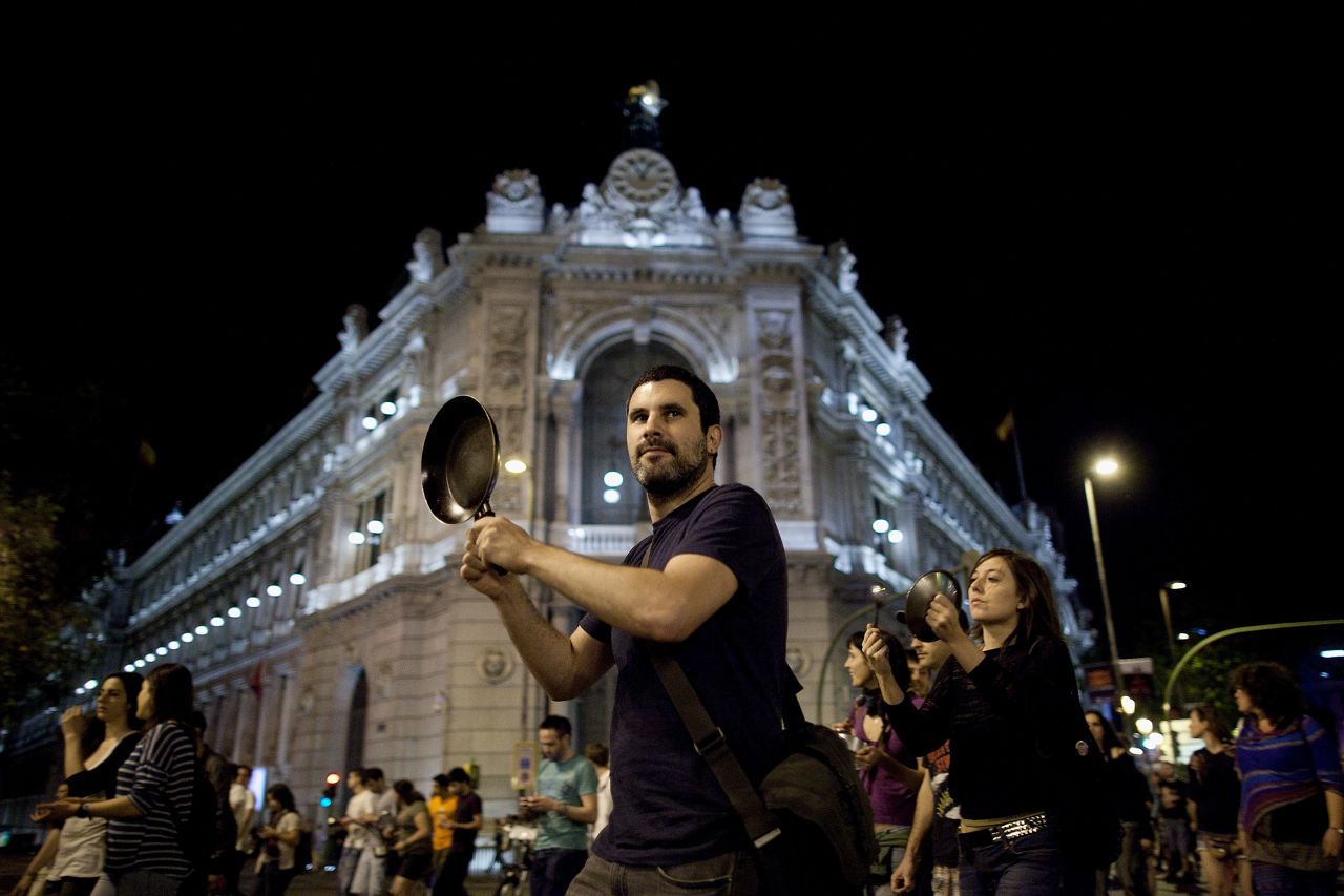 A protester hits a pot while walking past the Bank of Spain on May 15, 2012 in Madrid, Spain. Spain's 'Indignants' prepared events across Spain to mark the anniversary of their movement.