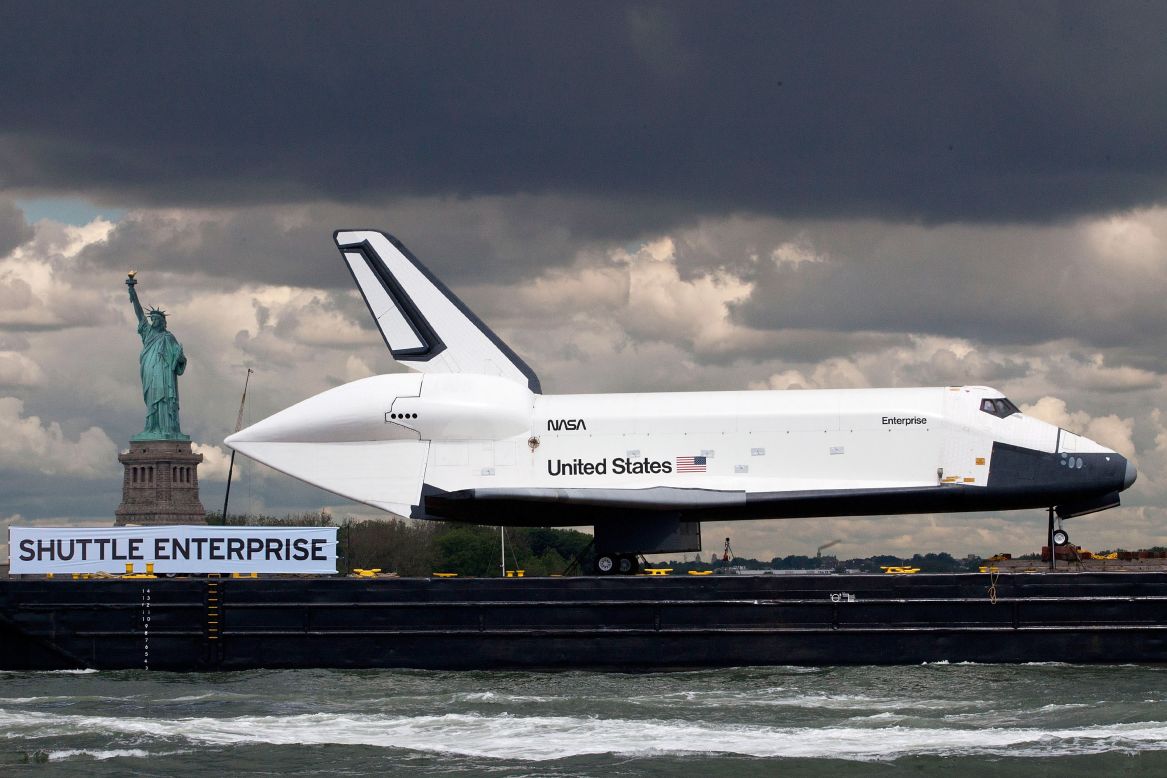 A barge carries the Space Shuttle Enterprise past the Statue of Liberty in New York Harbor on Wednesday, June 6. The shuttle is on its way to the USS Intrepid Museum, where it will be on display aboard the former aircraft carrier.
