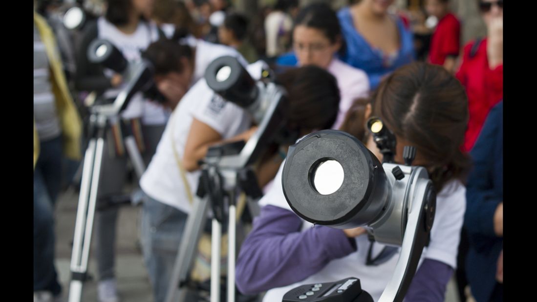 Astronomy students in Mexico City look at the sun through telescopes.