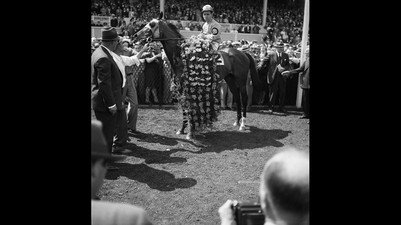 Count Fleet, who won the Triple Crown in 1943, is adorned with flowers after winning the Preakness that year.